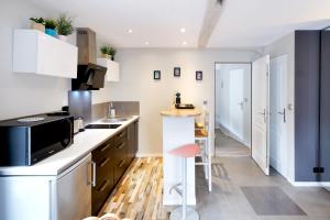 a kitchen with white cabinets and a red stool at Appartement, 2 à 4 pers in Urrugne