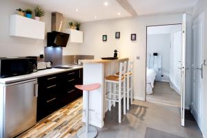 una cocina con barra y un bar con taburete en Appartement, 2 à 4 pers en Urrugne