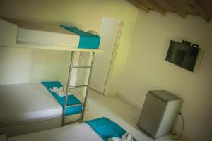 a small room with a bunk bed and a television at Hotel Lagotours in San Jerónimo