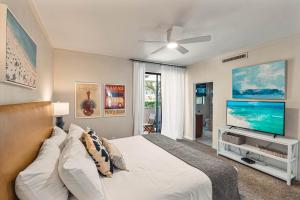 Schlafzimmer mit einem Bett und einem Flachbild-TV in der Unterkunft Kapalua Golf Villa 21V 1 in Kahana