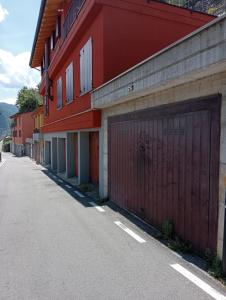 a red building with a garage on the side of a street at Casa Corinna, Lake View, Terrace, Private Garage! in Colonno