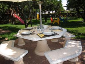 una mesa y sillas con platos y vasos. en Casa da Horta, Vale carro Olhos de Agua, en Albufeira