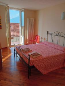 a bedroom with a bed with a red comforter at Casa Corinna, Lake View, Terrace, Private Garage! in Colonno