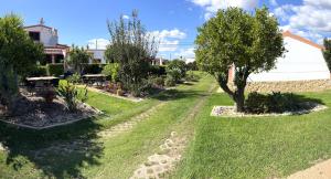 ogród z drzewami i trawą oraz budynek w obiekcie Casa da Horta, Vale carro Olhos de Agua w Albufeirze