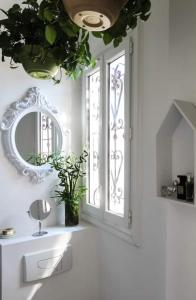 La salle de bains est pourvue d'un miroir, d'un lavabo et d'une fenêtre. dans l'établissement La Palmeraie, à Nice