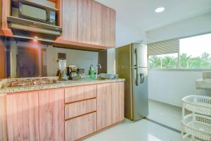 una cucina con armadi in legno e frigorifero in acciaio inossidabile di Ayenda Salome Apartments a Cartagena de Indias