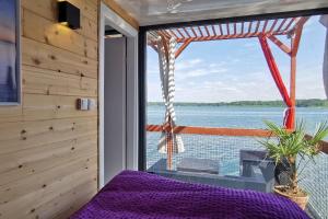Schlafzimmer mit einem Fenster mit Blick auf das Wasser in der Unterkunft Ma maison sur L'eau - Lac du Der in Giffaumont
