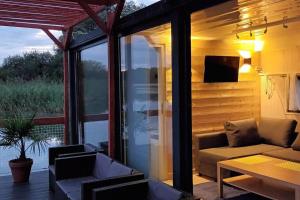 a screened in porch with a couch and a table at Ma maison sur L'eau - Lac du Der in Giffaumont-Champaubert