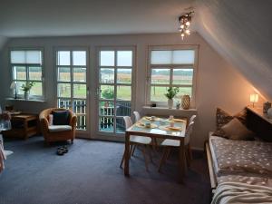 a living room with a table and chairs and windows at Landidylle mit Garten, Whirlpool und Klima in Reken