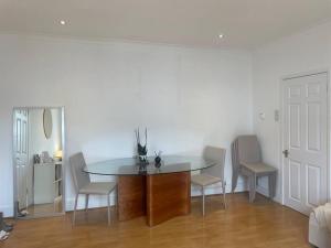 a dining room with a table and chairs in a room at Spacious 1-bedroom apartment in Belsize Village in London