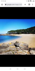 uma vista para uma praia com rochas e areia em Finca rústica cerca playa todas las comodidades em Bueu