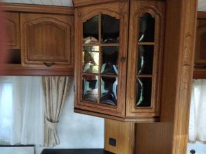 um armário de madeira com portas de vidro num quarto em Finca rústica cerca playa todas las comodidades em Bueu