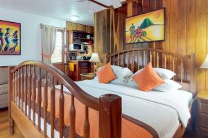 a bedroom with a wooden bed with orange pillows at Latitude Adjustment Gold Standard Certified in Hopkins +28 photos