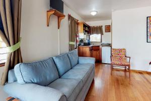 een woonkamer met een blauwe bank en een keuken bij Latitude Adjustment Gold Standard Certified in Hopkins