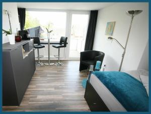 a bedroom with a bed and a desk with chairs at Apartment TRAUM - ruhig gelegen, schnell erreichbar, mit Balkon in Braunschweig +2 photos