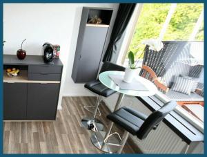 eine kleine Küche mit einem Tisch und Stühlen sowie einem Fenster in der Unterkunft Moderne Wohnung mit Wellnessdusche und Strandkorb in Braunschweig