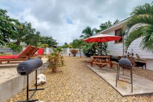 een patio met een tafel en een rode parasol bij Latitude Adjustment Gold Standard Certified in Hopkins