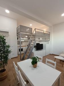 a living room with a white table and a staircase at MiniLoft Baiona - in Baiona