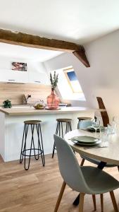 - une cuisine et une salle à manger avec une table et des chaises dans l'établissement Chez Clément et Mathilde -Duplex climatisé Hyper centre , tout équipé, à Saint-Amand-les-Eaux