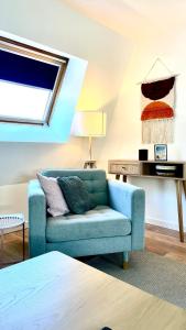 - un salon avec un canapé bleu et une table dans l'établissement Chez Clément et Mathilde -Duplex climatisé Hyper centre , tout équipé, à Saint-Amand-les-Eaux