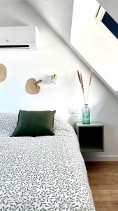 - une chambre avec un lit et un oreiller vert dans l'établissement Chez Clément et Mathilde -Duplex climatisé Hyper centre , tout équipé, à Saint-Amand-les-Eaux