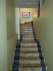 una escalera en un edificio con un cartel en la pared en Hostal David Alejandro, en Quito