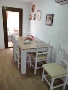 un comedor blanco con mesa y sillas en Casa Rural La Simona, en Belmonte