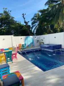 a pool with colorful chairs and tables next to a fence at HOTEL ARRECIFE in Santa Veronica