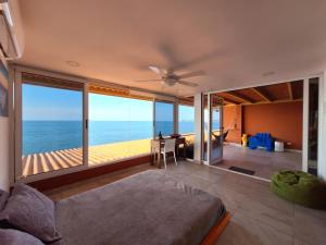 a living room with a ceiling fan and a view of the ocean at Malibu Rooftop in Nueva Gorgona