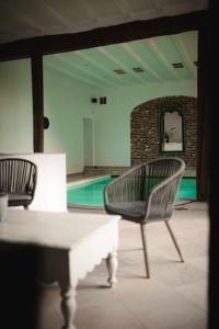 two chairs and a table in a room with a pool at Gîte de l'Ourchet in Ramillies +23 photos