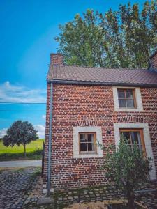 a brick house with two windows on a street at Gîte de l'Ourchet in Ramillies