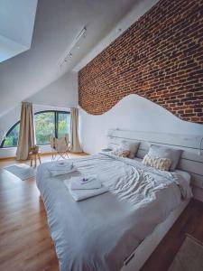 a bedroom with a large bed with a brick wall at Gîte de l'Ourchet in Ramillies