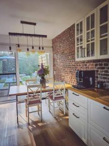 a kitchen with a table and chairs and a brick wall at Gîte de l'Ourchet in Ramillies