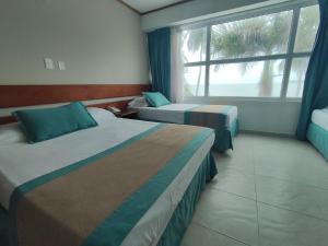 a hotel room with two beds and a window at Portobelo Beach in San Andrés