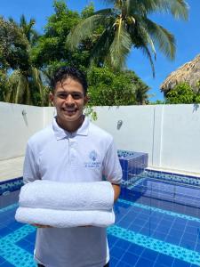 a man holding towels in front of a pool at HOTEL ARRECIFE in Santa Veronica