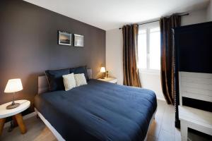 Un dormitorio con una cama azul y una ventana. en Appart 12 pers 5km plage Hendaye, en Urrugne