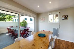Un comedor con mesa y sillas de madera. en Appart 12 pers 5km plage Hendaye, en Urrugne