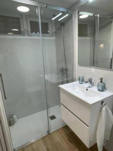 baño blanco con ducha y lavamanos en MiniLoft Baiona -, en Baiona