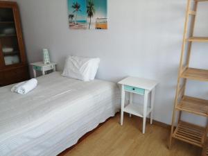 a bedroom with a bed and a night stand and a ladder at Casa do Mar in Foz do Arelho