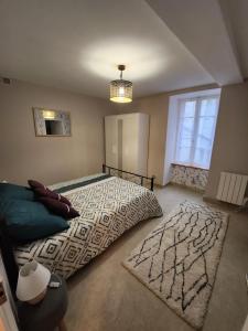 a bedroom with a large bed with a rug at Le p'tit gîte d'Edmé in Montbard