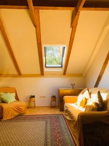 a attic room with two beds and a window at Home of arts and creation, Erdei alkoto studio in Kismaros
