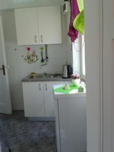 eine kleine Küche mit weißen Schränken und einer Spüle in der Unterkunft Apartment Ana in Split