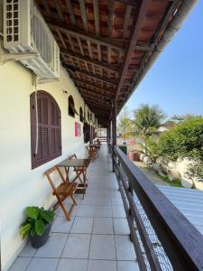 un porche de una casa con mesa y bancos en CHILL INN HOSTEL & POUSADA CENTRO en Paraty