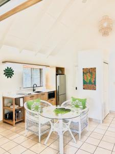 a kitchen with a table and chairs in a room at Motu Beachfront Art Villas in Rarotonga