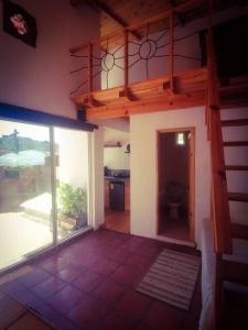 un salon avec un escalier et une grande fenêtre dans l'établissement casa camelina, à Guanajuato