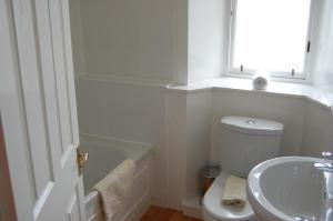 baño con aseo y lavabo y ventana en Royal Mile Cranston, en Edimburgo
