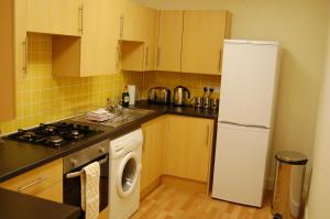 a kitchen with a refrigerator and a washing machine at Royal Mile Cranston in Edinburgh