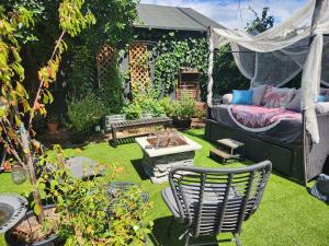 a garden with a bed and a couch in a yard at Tranquility at the House of Alchemy Hollywood in Los Angeles