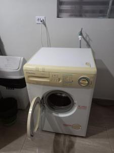 uma máquina de lavar e secar roupa numa pequena sala com em Casa 50 mts da praia Caravelas PR com ventiladores em Matinhos