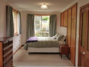 a bedroom with a bed and a large window at Flinders Island Masters Quarters - Lady Barron in Lady Barron